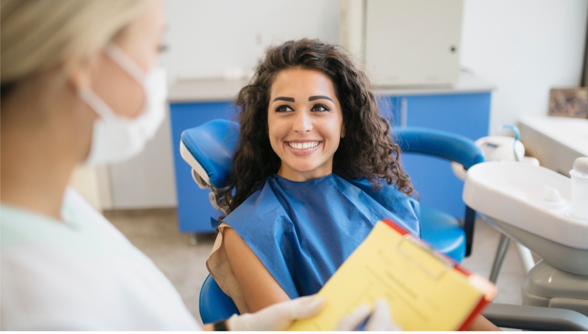 A patient smiling while talking with a dentist