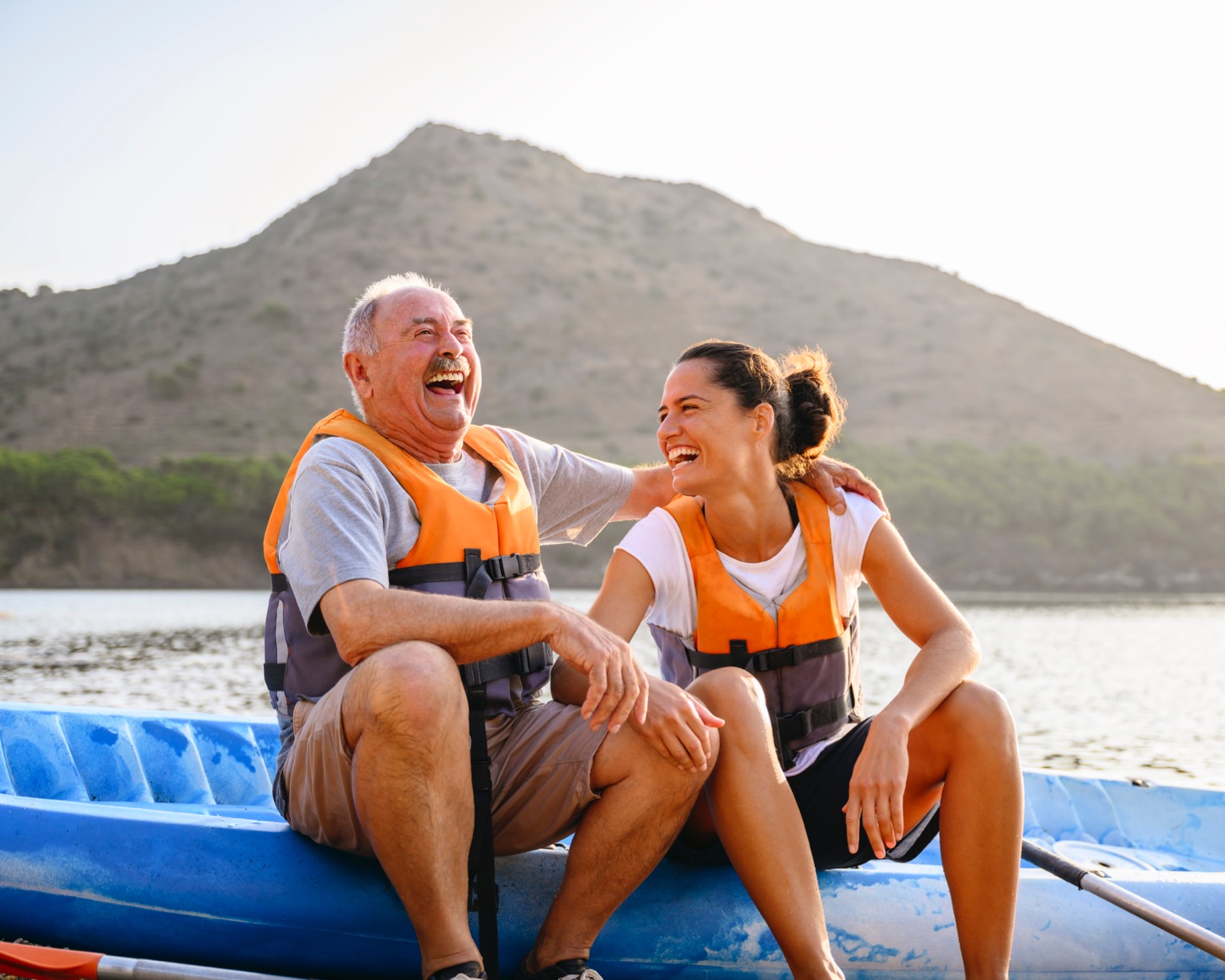 Two family members laughing while sitting on a kayak