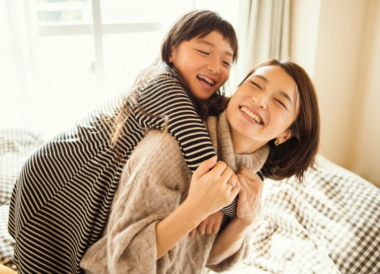 A mother and daughter smiling
