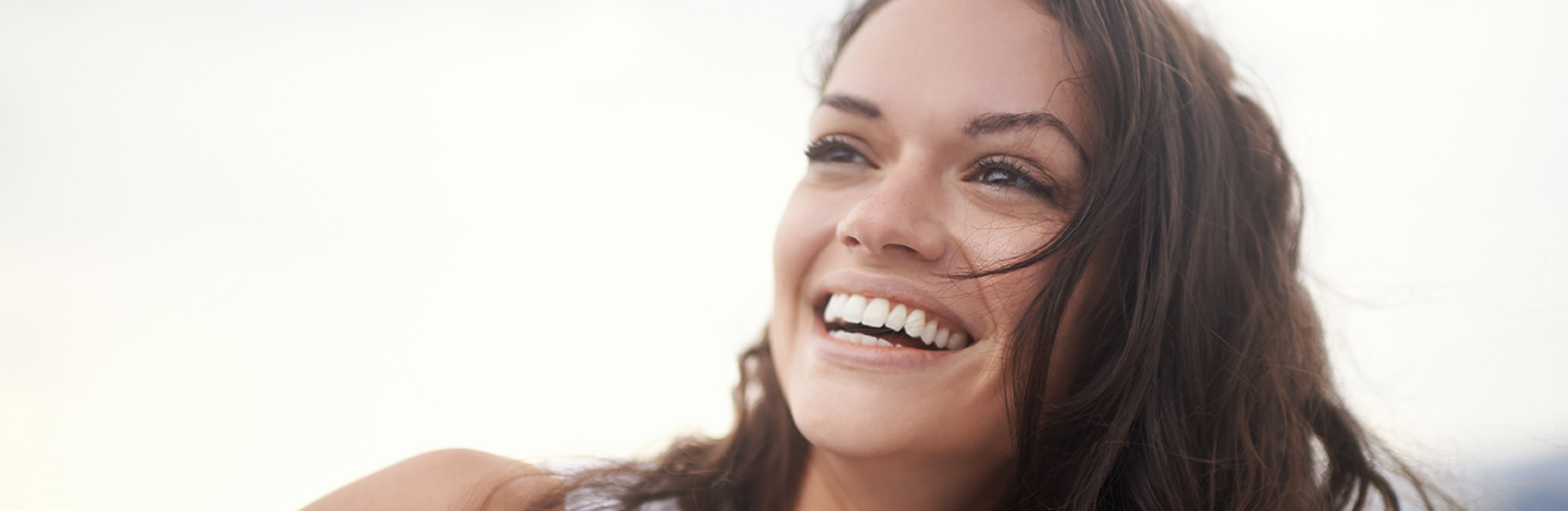A woman smiling outside