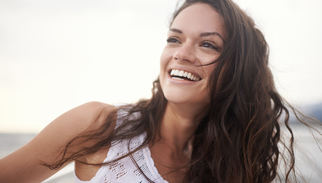 A woman smiling outside