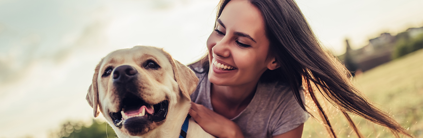 A woman playing with her dog outside