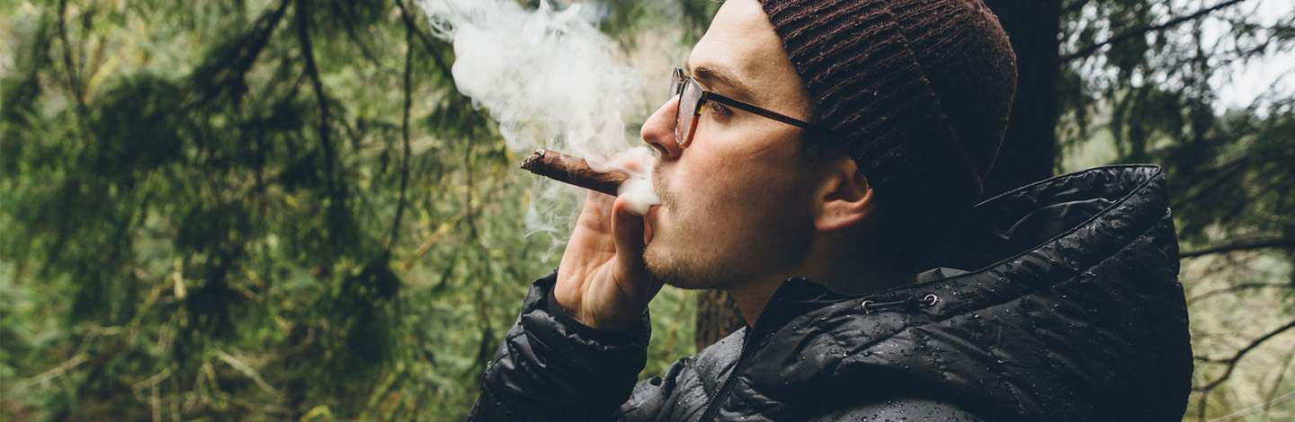 A man smoking a cigar outside