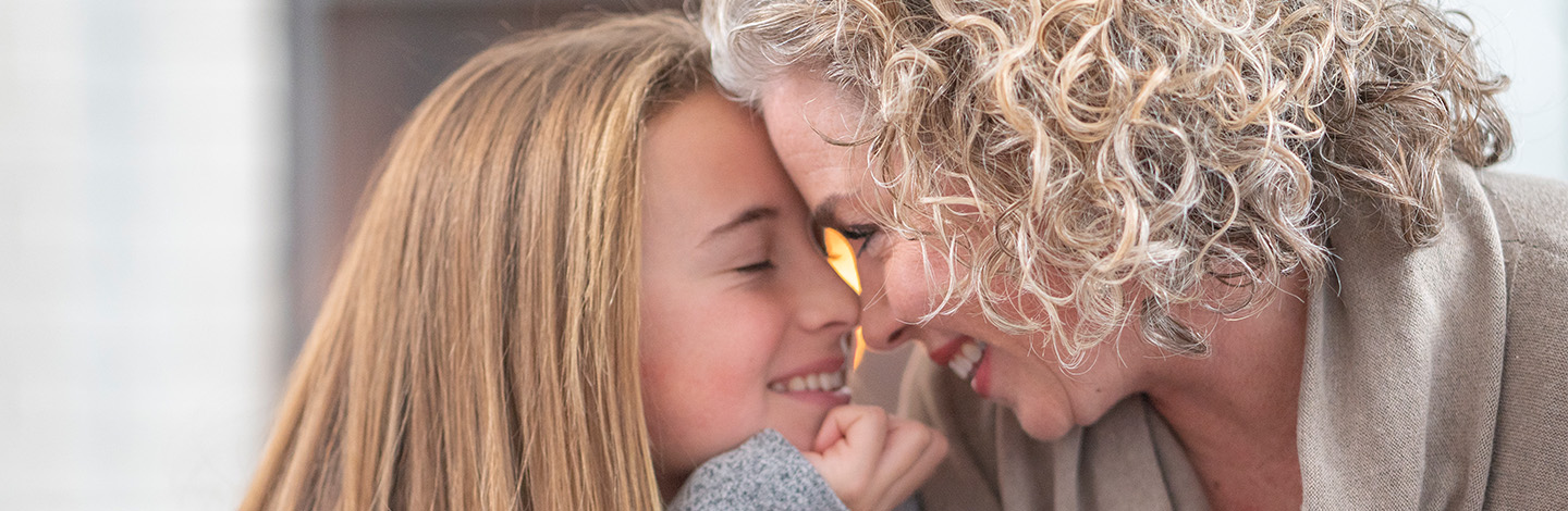 A mother and child nose to nose while smiling