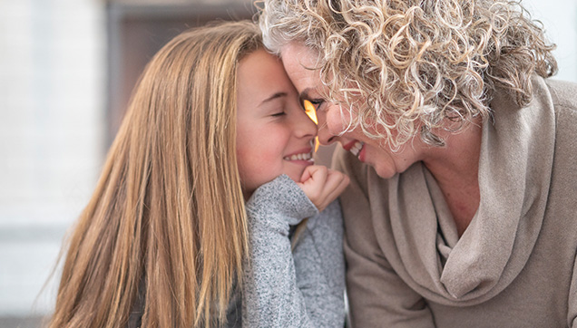 A mother and child nose to nose while smiling
