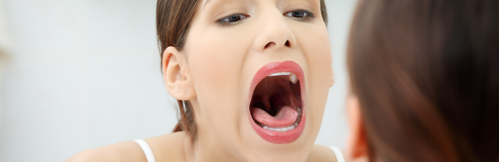 A woman looking at her mouth in a mirror