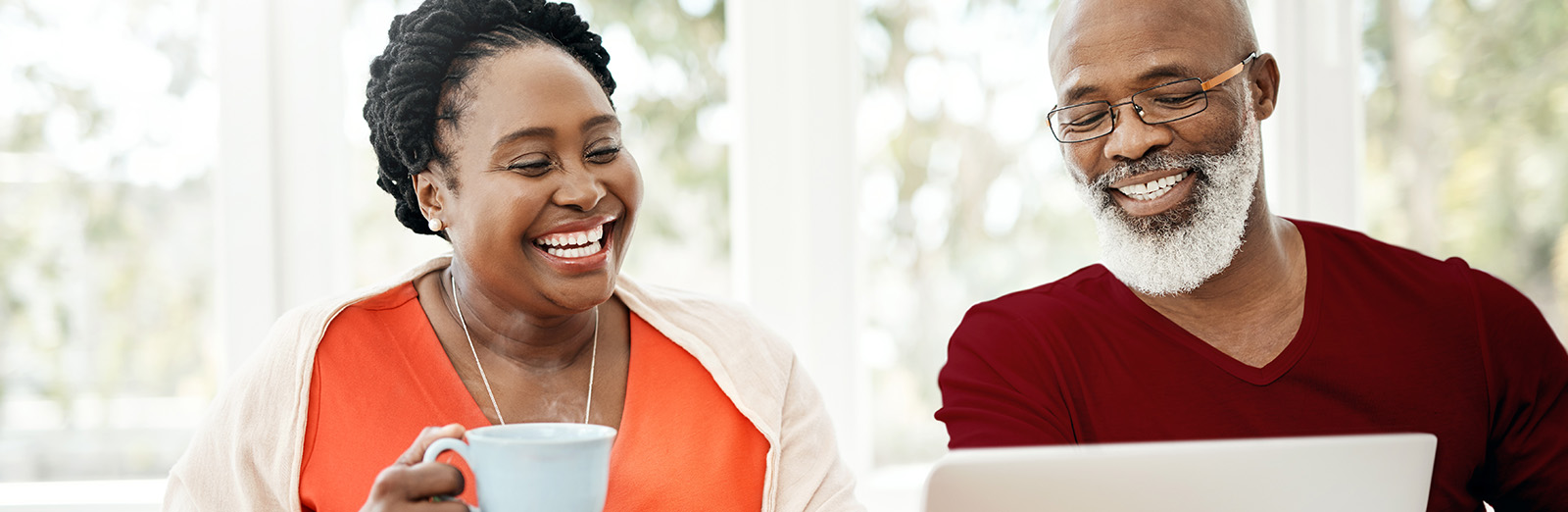 A couple looking at a laptop and smiling