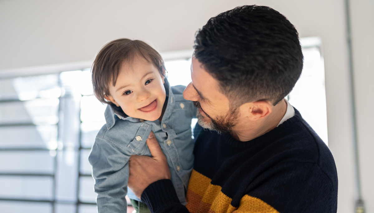 A  father holding a child and laughing
