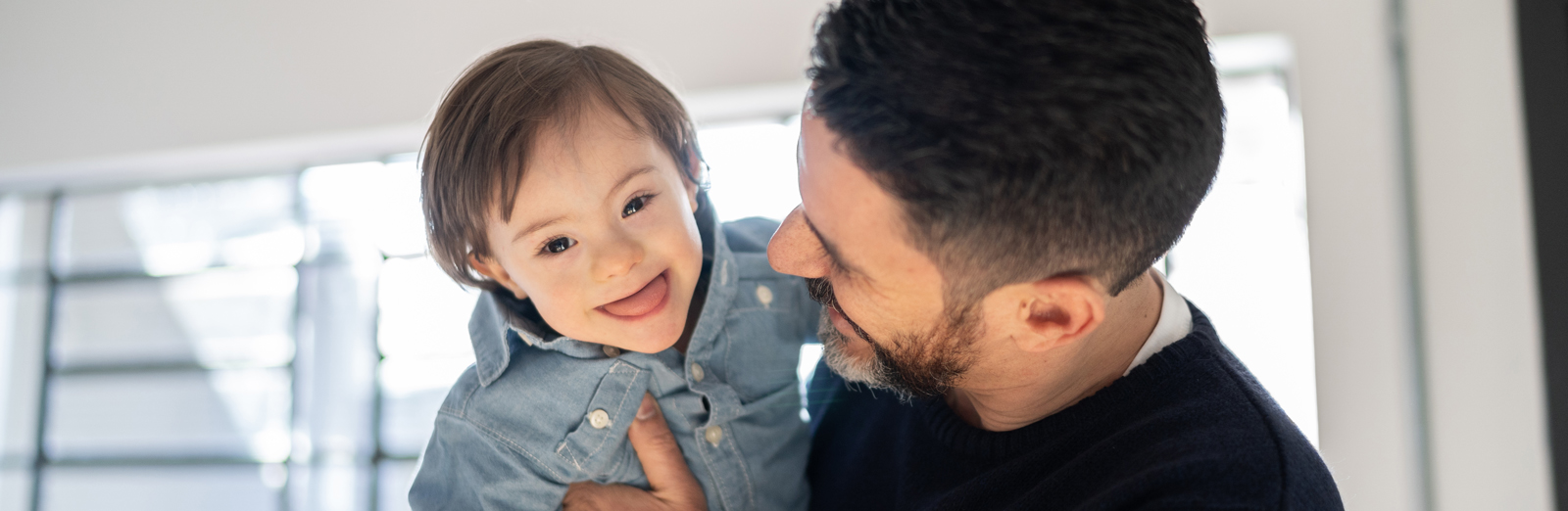 A  father holding a child and laughing