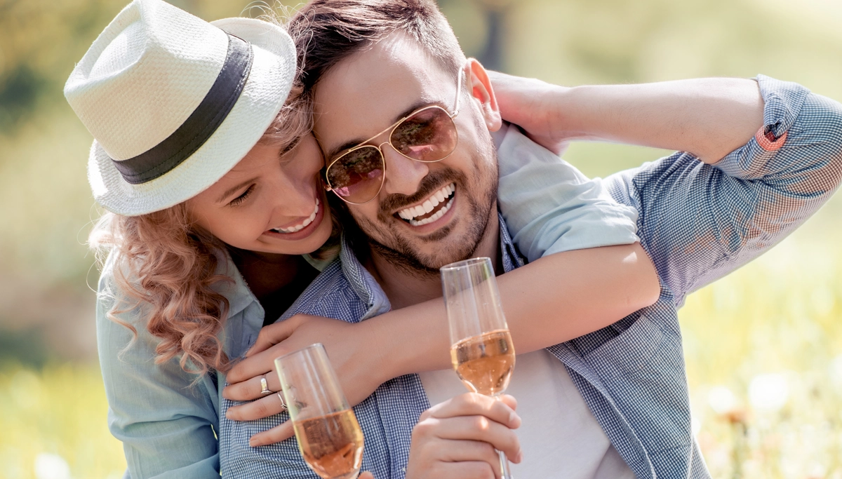 A couple drinking wine together in a field