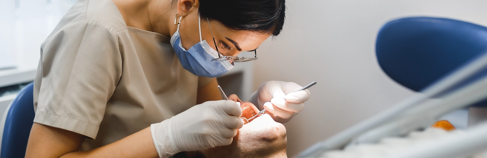 dentist-examining-patients-teeth-1600x522.webp