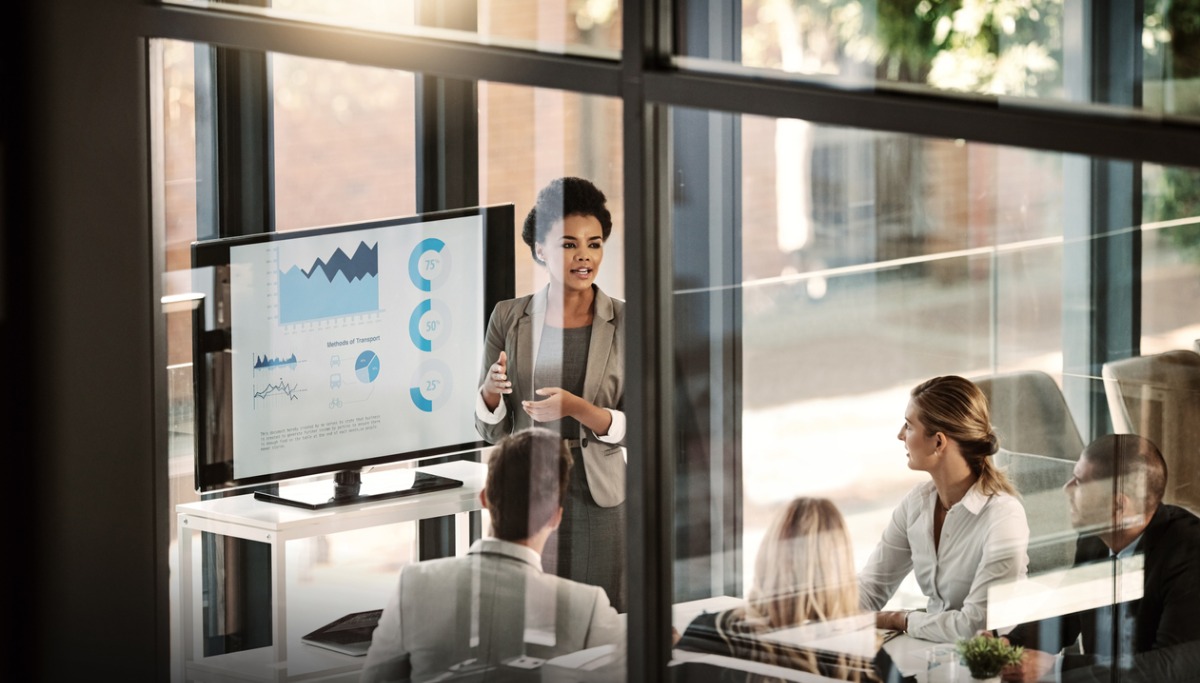 A woman presenting graphs to a group of people