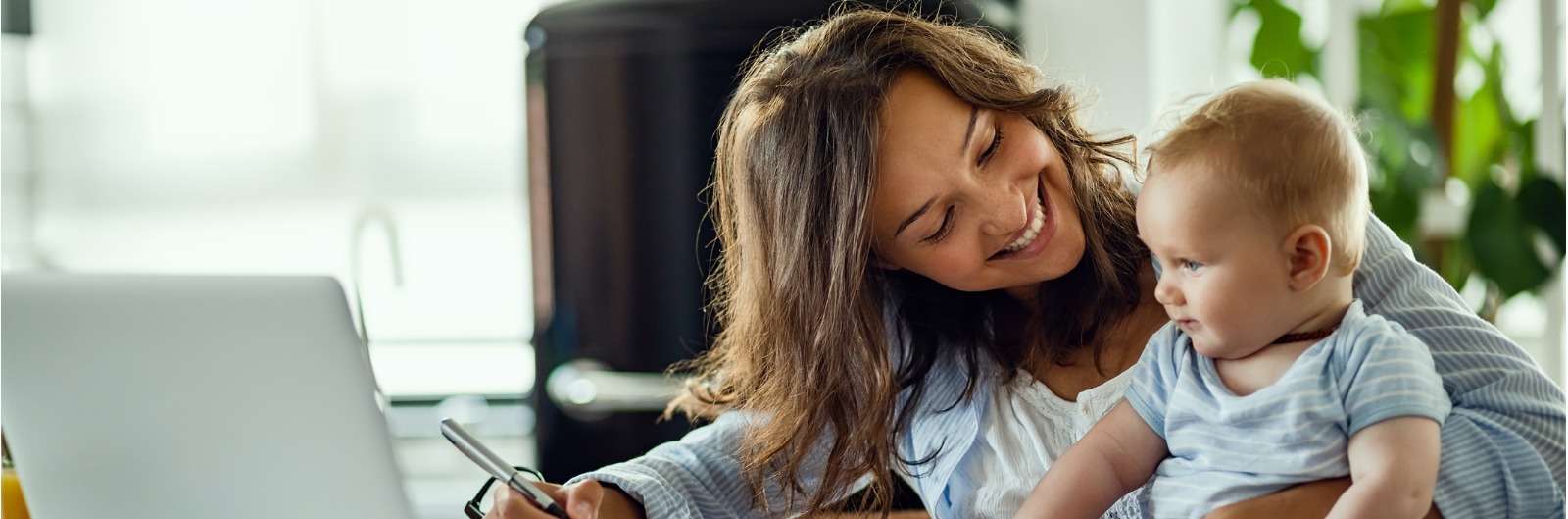 happy-mother-talking-to-her-baby-while-working-at-home-picture-1600x529.jpg