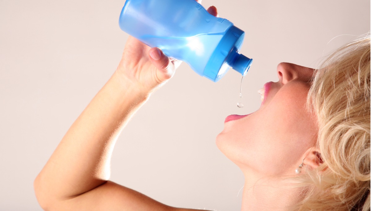A person squeezing water into their mouth