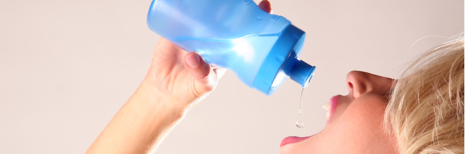 A person squeezing water into their mouth