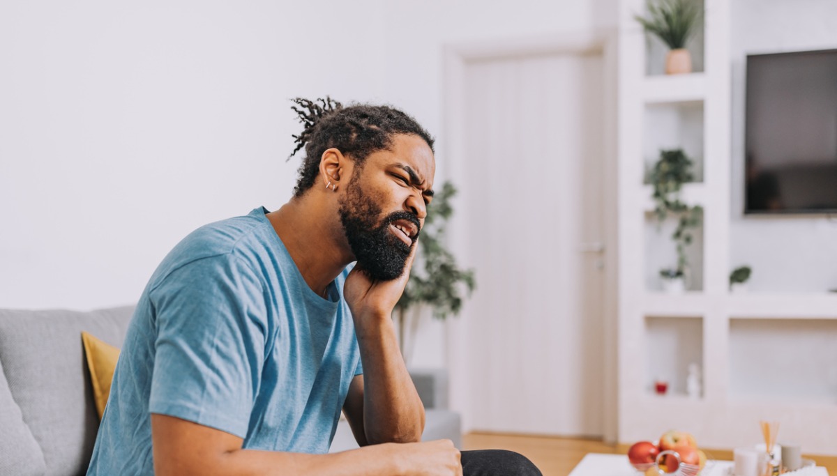 A man holding his mouth in pain
