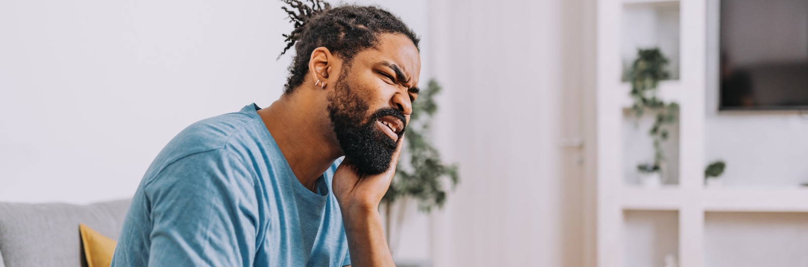 A man holding his mouth in pain