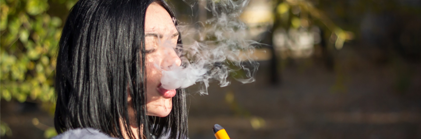 A girl exhaling smoke after vaping