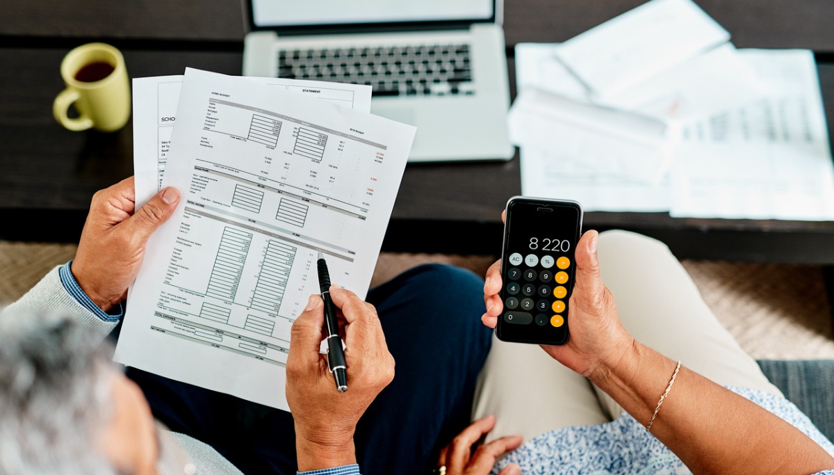 Two people tallying up the cost on a calculator