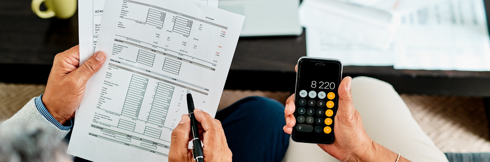 Two people tallying up the cost on a calculator