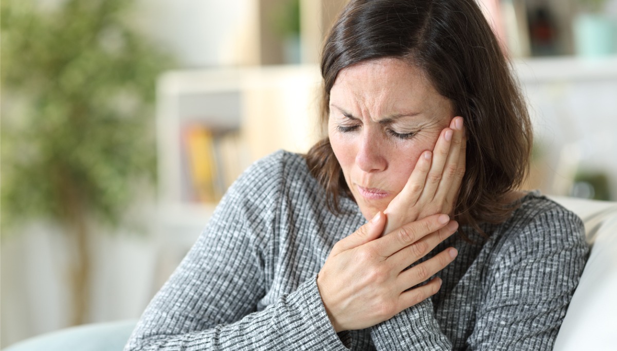 A woman holding her face in pain