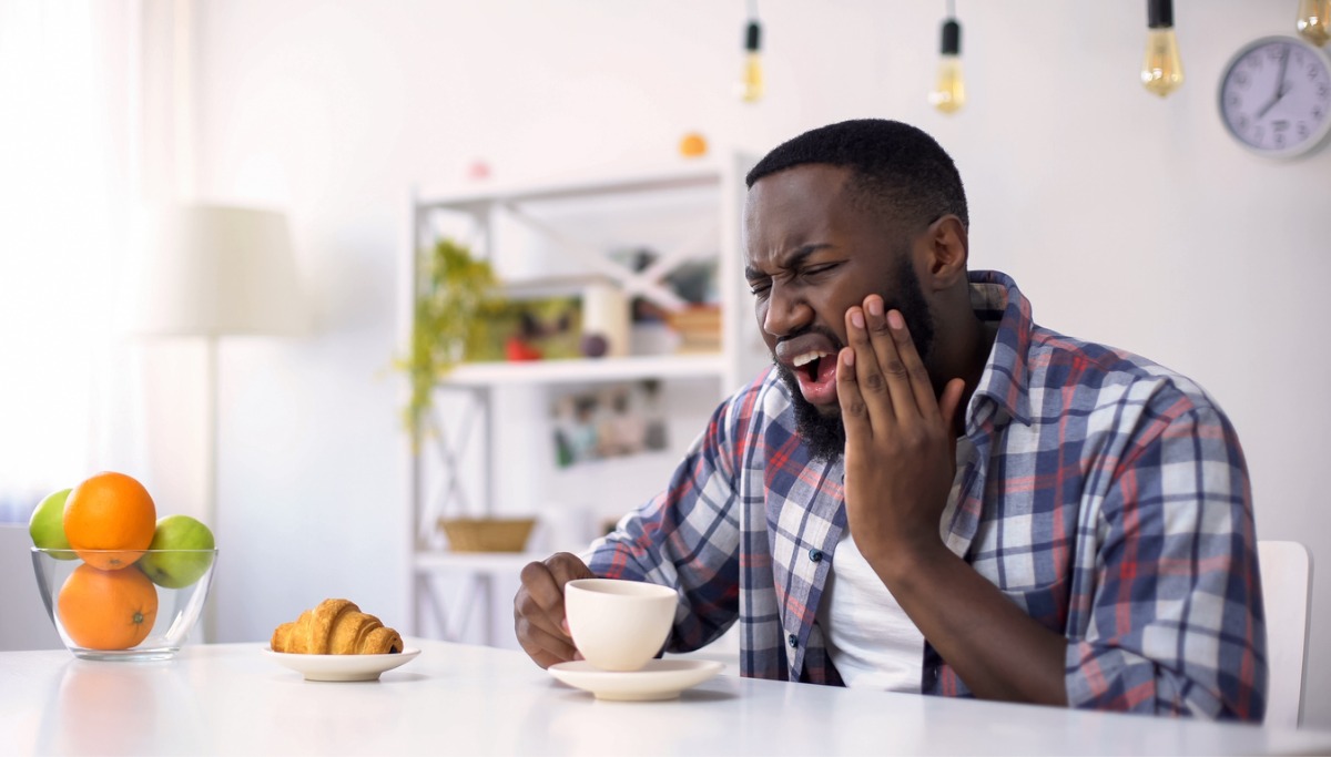 A man holding his mouth in pain