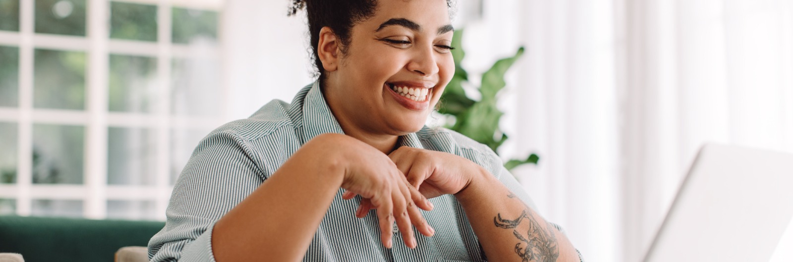 A woman using a laptop and smiling