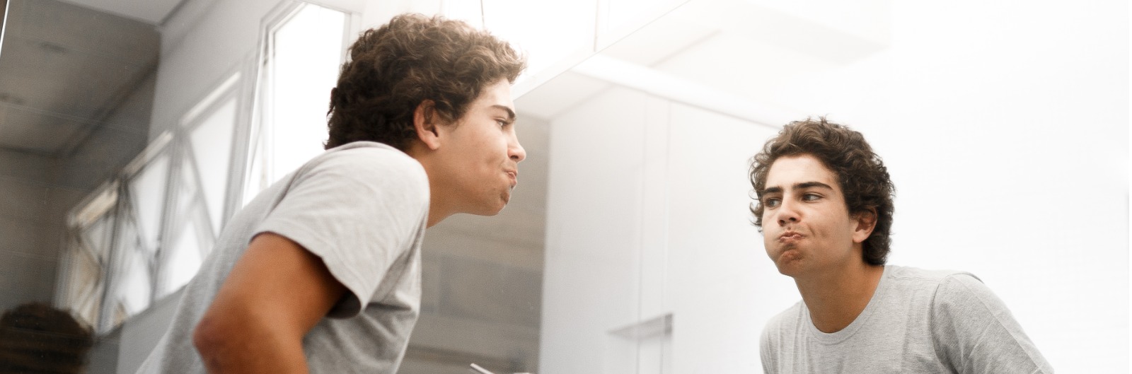 A boy using mouthwash in a bathroom