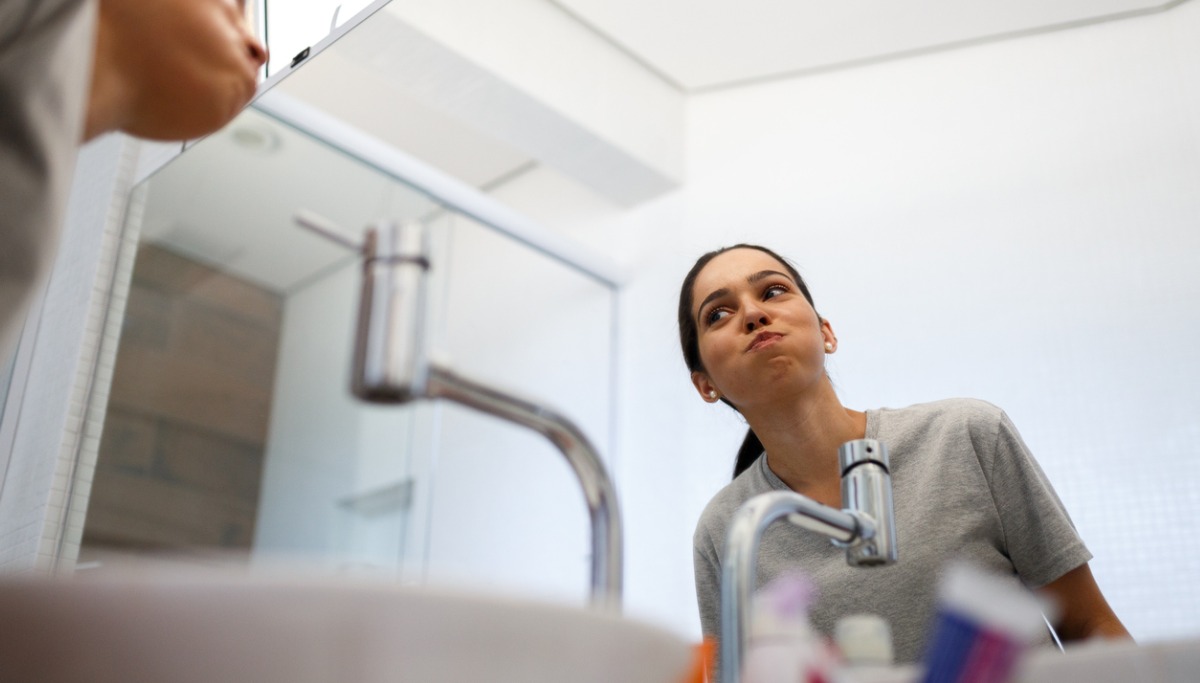 A woman using mouthwash