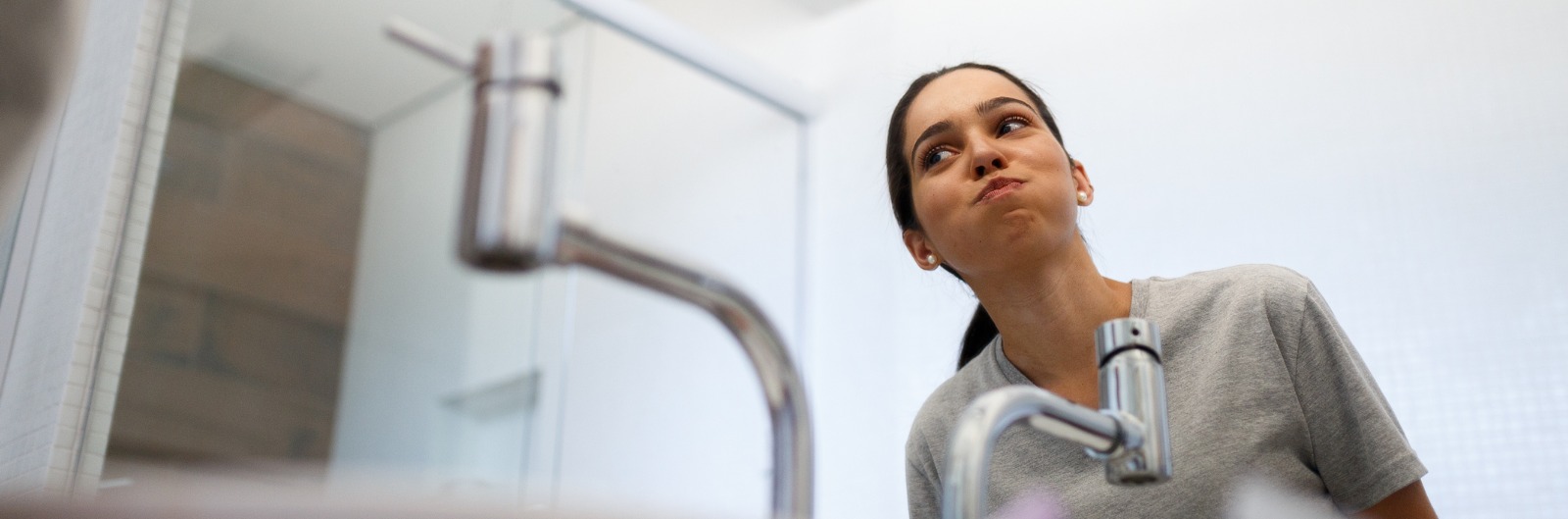 A woman using mouthwash