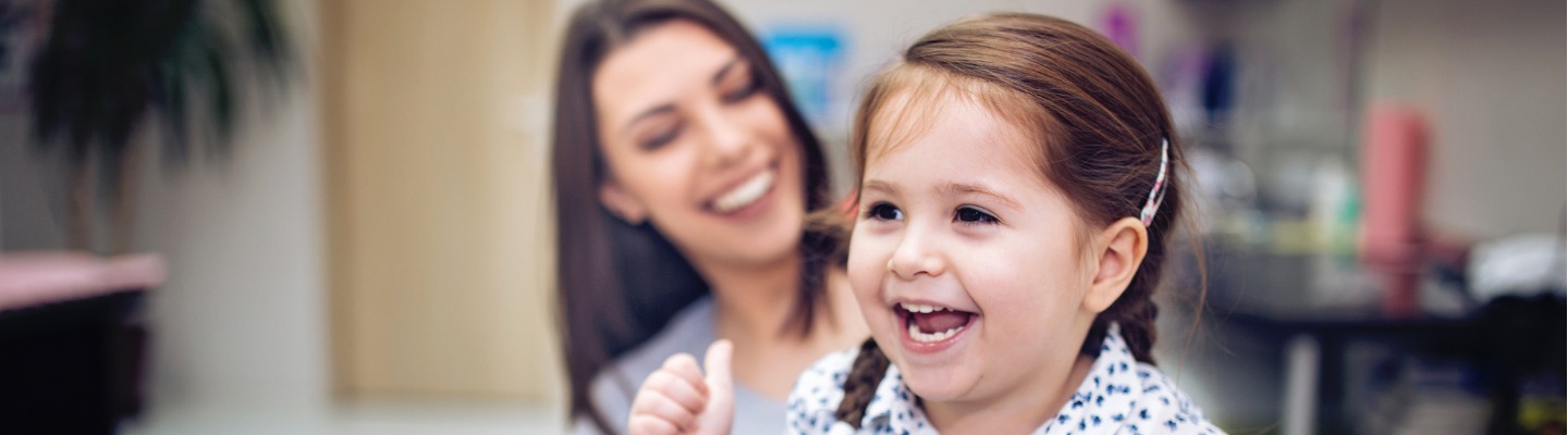 A young girl smiling while in a dentist office