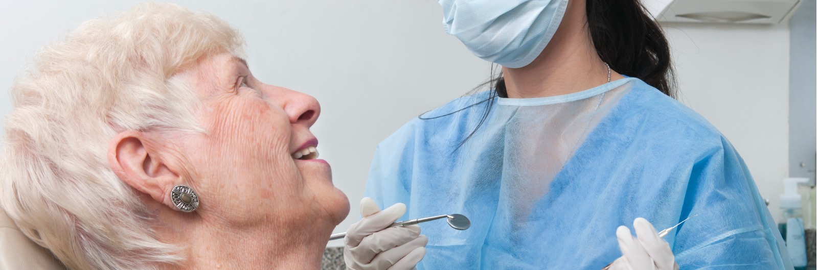 A woman looking up at a dentist and smiling