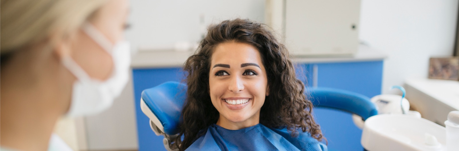 A patient smiling while talking with a dentist