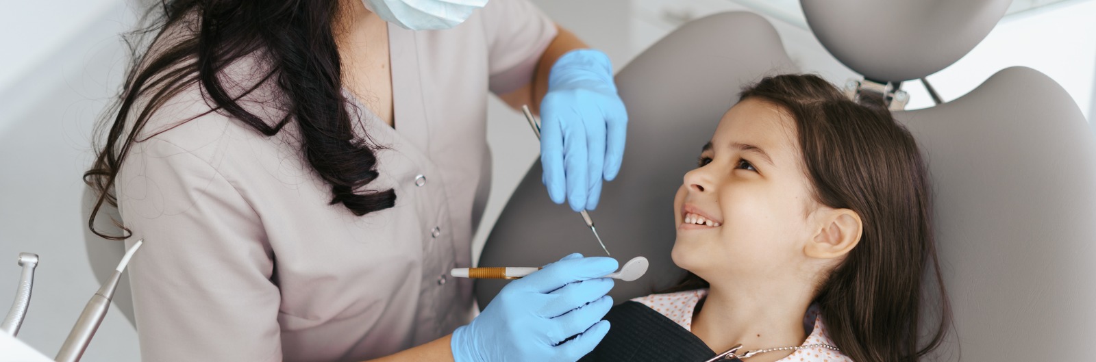 A dentist conducting an exam on a young girl