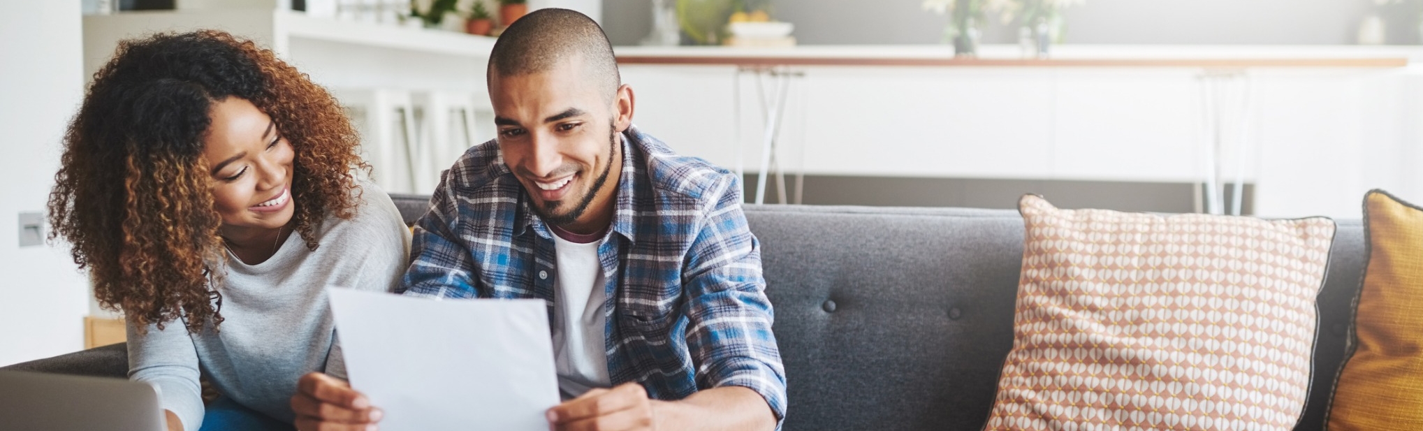 A couple sitting on a couch looking at their benefits