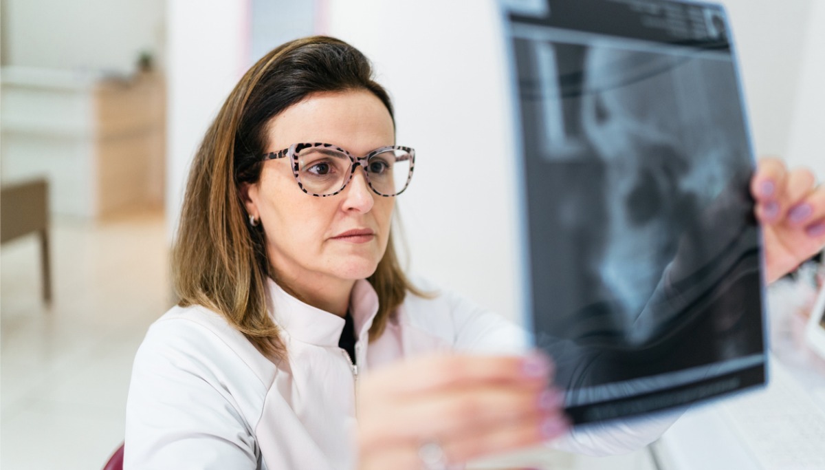 A dentist looking at an oral x-ray