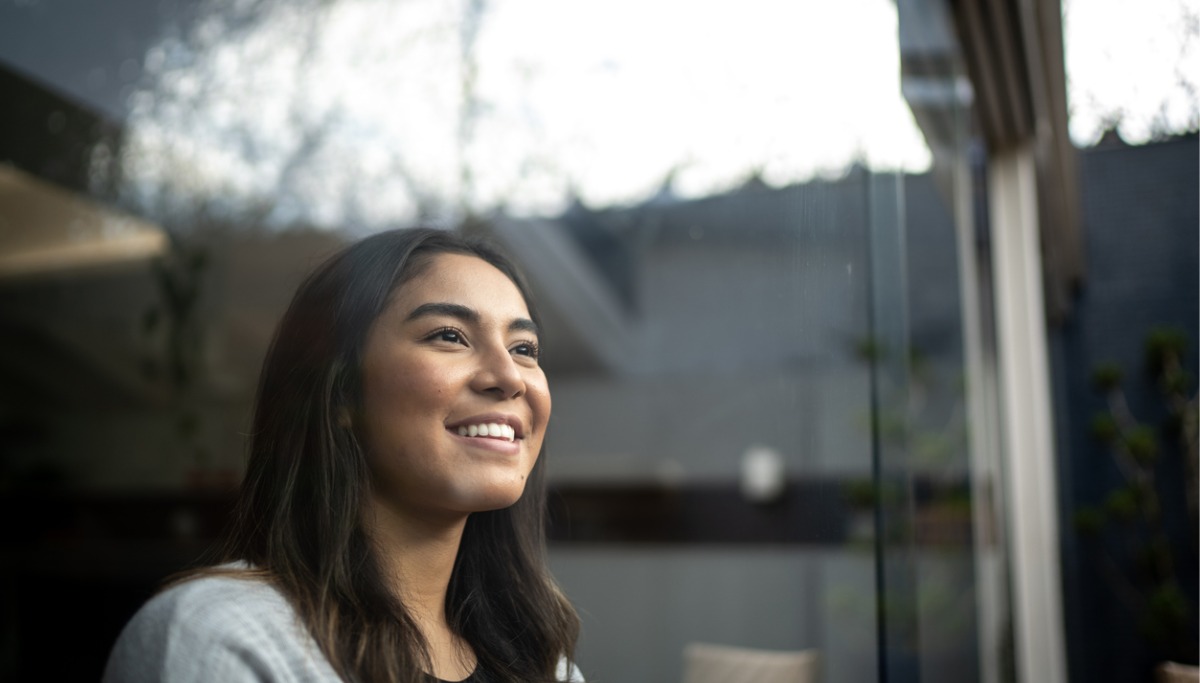 A girl smiling and looking out the window