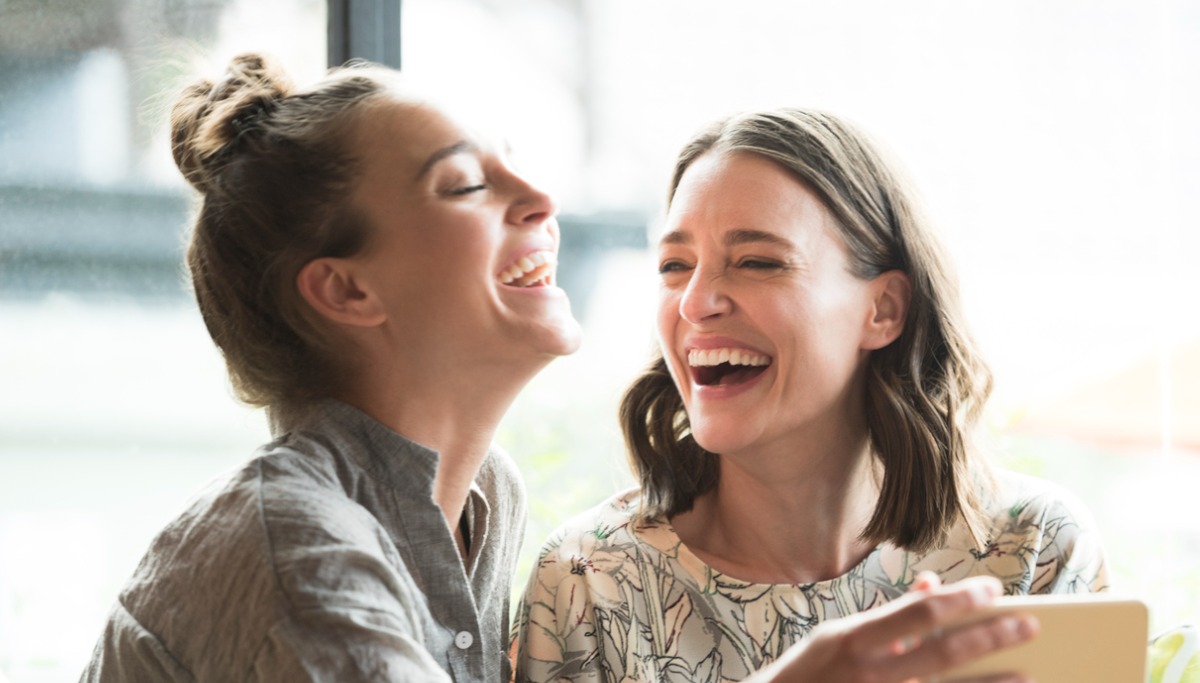 woman-holding-mobile-phone-with-freind-laughing-picture-id1200x683.jpg