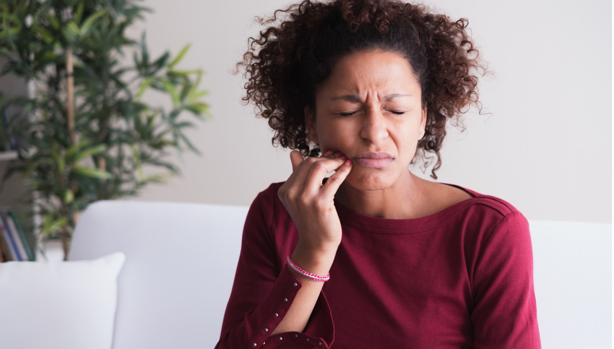 A woman holding her jaw in pain