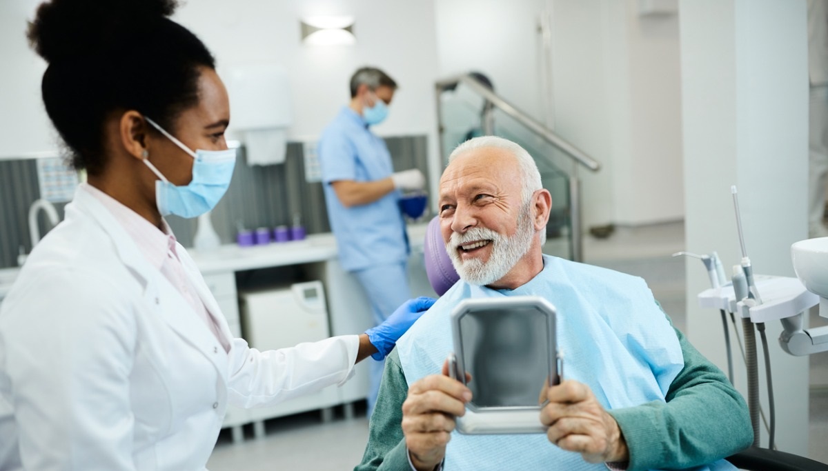 A dentist and patient laughing