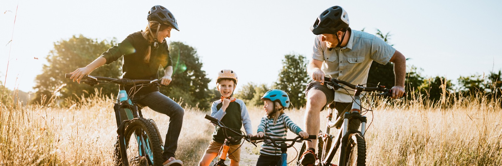 family-mountain-bike-riding-together-on-sunny-day-1600x529.jpg