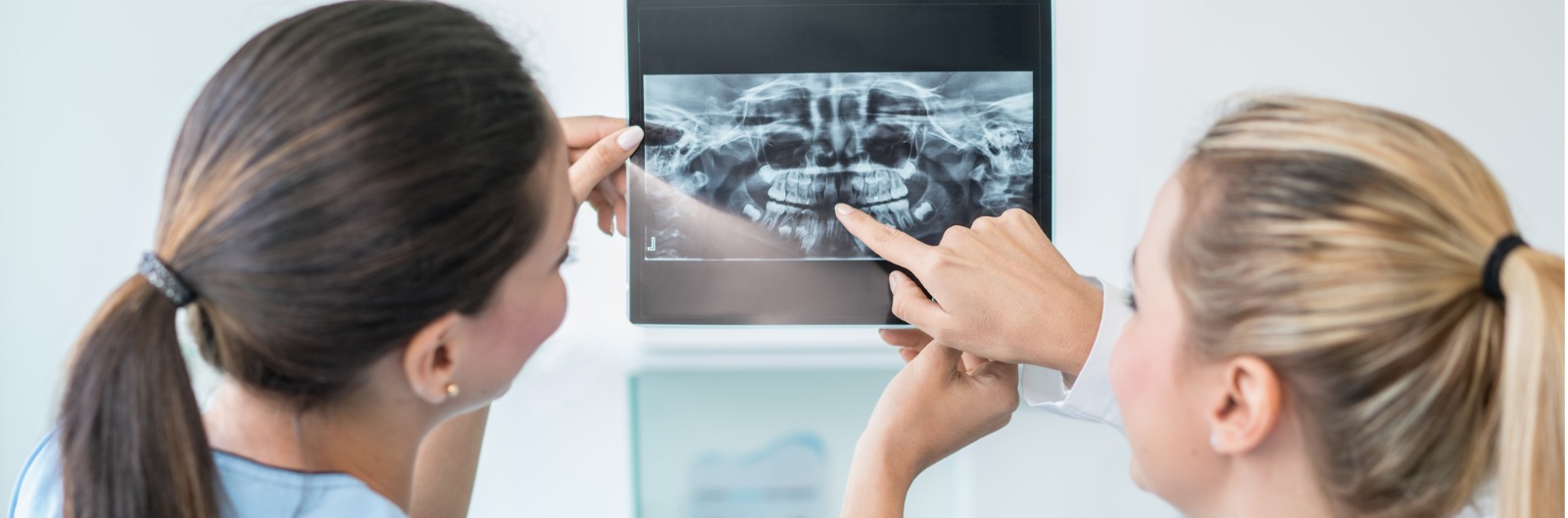 Two dentist looking at an x-ray of a mouth