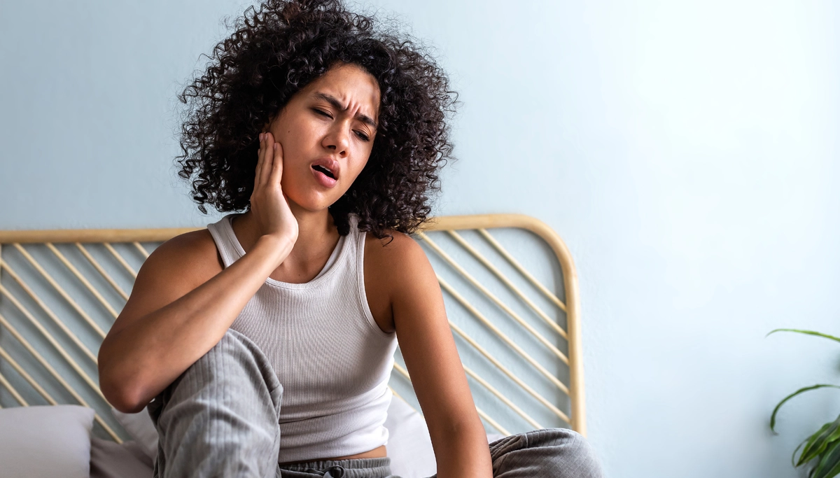 A woman holding her jaw in pain