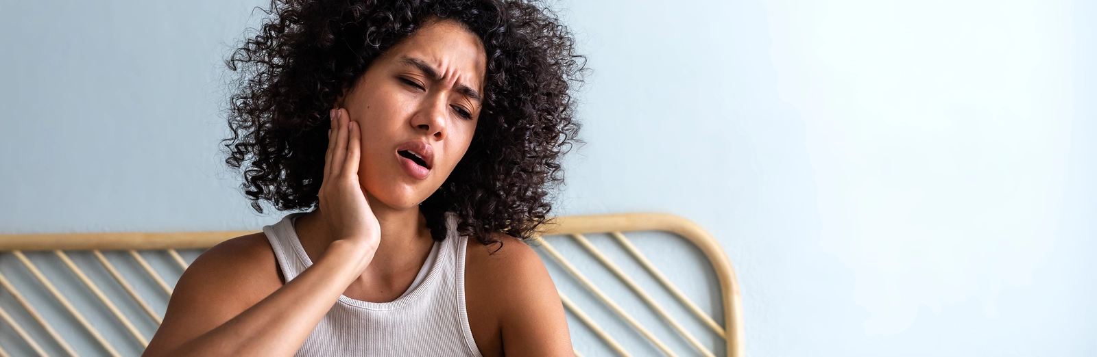 A woman holding her jaw in pain