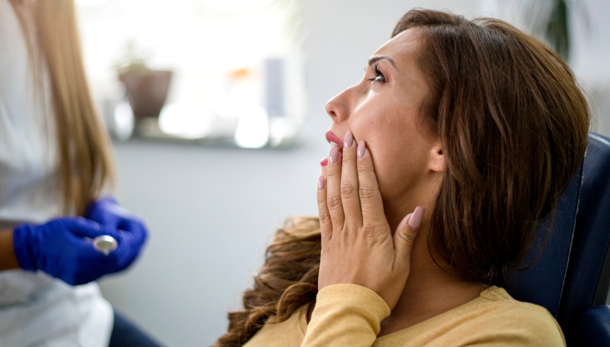 A patient holding her mouth in pain
