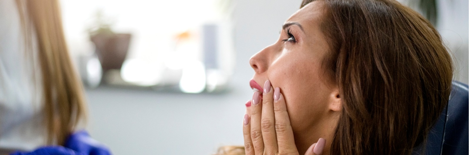 A patient holding her mouth in pain