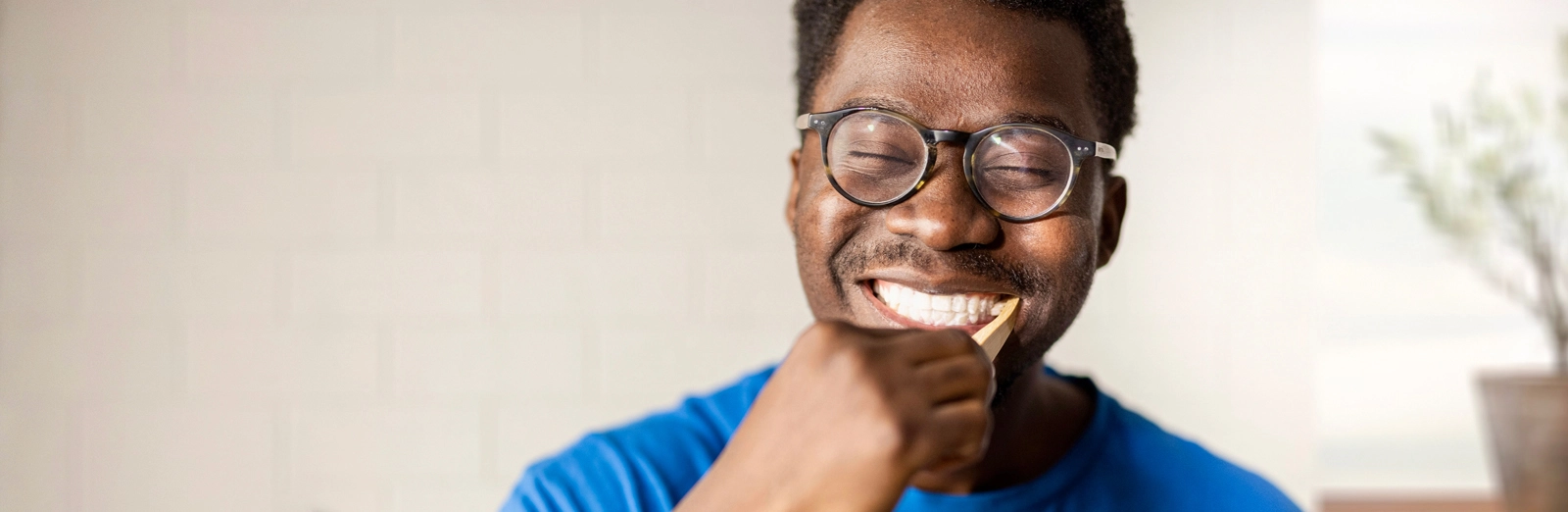 A man smiling and brushing his teeth