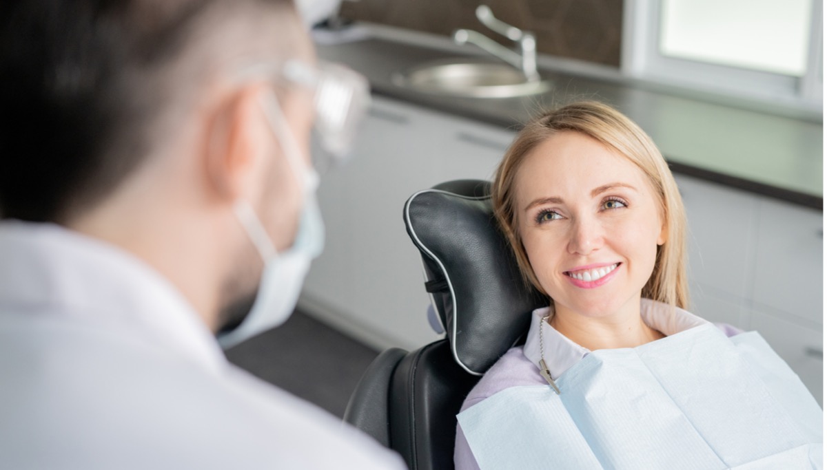 A patient looking at a dentist and smiling