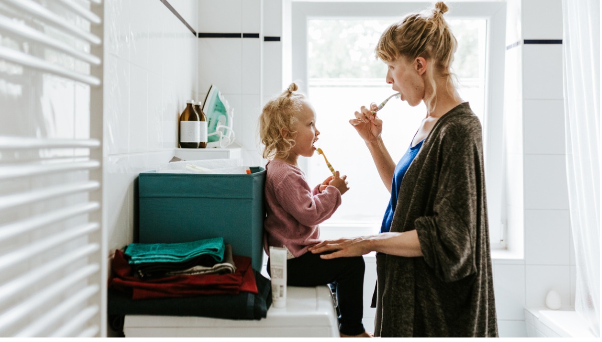A mother and child brushing their teeth
