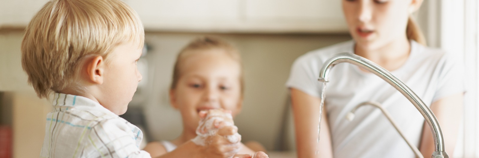 Three children washing their hands